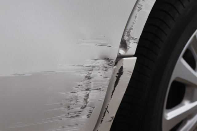左側面に擦り傷がある白い車
